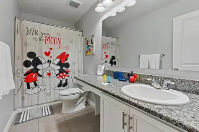 a bathroom with a sink and a toilet and a mirror at Amazing 4BdrmsPrivate Hot Tub7 miles from Disney in Kissimmee