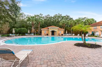 a swimming pool with two chairs and a house at Amazing 4BdrmsPrivate Hot Tub7 miles from Disney in Kissimmee