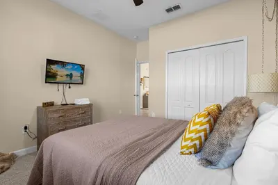 a bedroom with a bed and a tv on a wall at Perfect Disney Holiday! Private Pool, Spa, Resort! in Kissimmee