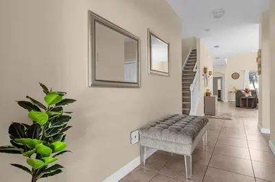a living room with a chair and a staircase at Perfect Disney Holiday! Private Pool, Spa, Resort! in Kissimmee