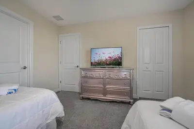 a bedroom with two beds and a tv on a dresser at Charming Home Ideal Location Spacious Game Room in Kissimmee