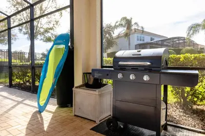 a blue and yellow bird standing next to a grill at Hibiscus Villa in Orlando
