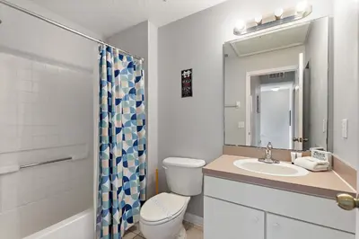 a bathroom with a toilet and a sink and a mirror at Serene Stay at Terra Verde Resort by Shine Villas 111 townhouse in Kissimmee