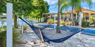 a hammock on the beach in front of a house at Serene Stay at Terra Verde Resort by Shine Villas 111 townhouse in Kissimmee