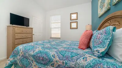 a bedroom with a bed and a tv on a dresser at 8150 Fan Palm in Kissimmee