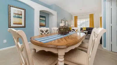 a dining room with a wooden table and chairs at 8150 Fan Palm in Kissimmee