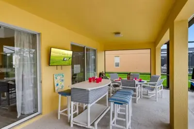 a room with a table and chairs and a screen at Lakefront 6BR Resort Pool Home Near Disney in Kissimmee