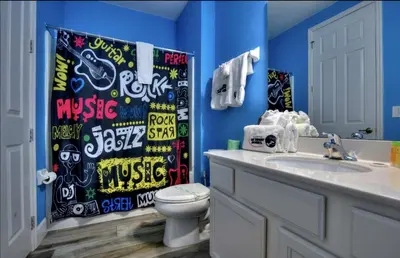 a bathroom with a toilet and a shower curtain at All Vacation Large Pool Home w-Cinema-Bowling Alley-Sleep 40 in Kissimmee