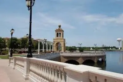 a bridge over a river with a building in the background at The Tiny Cottage in the Springs/ Central FL in Altamonte Springs
