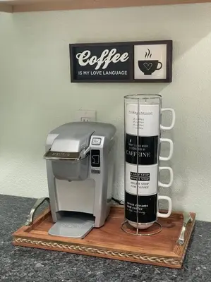 a coffee machine on a wooden tray with a sign at The Tiny Cottage in the Springs/ Central FL in Altamonte Springs