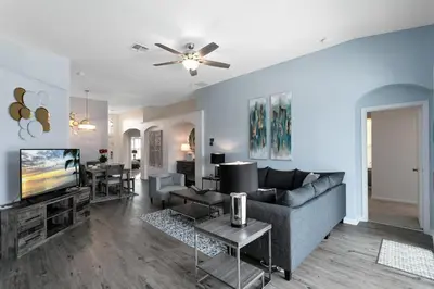 a living room with a couch and a tv at Immaculate 4 bedrooms 3 bathroom in Windsor Palms in Kissimmee