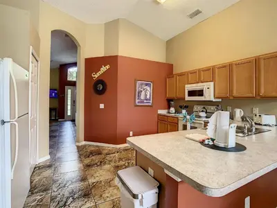 a kitchen with a counter and a refrigerator at Emerald Island Resort 4 bed 3 bath with pool/spa in Kissimmee