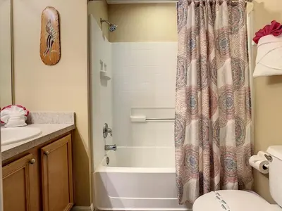 a bathroom with a shower curtain next to a toilet at Emerald Island Resort 4 bed 3 bath with pool/spa in Kissimmee