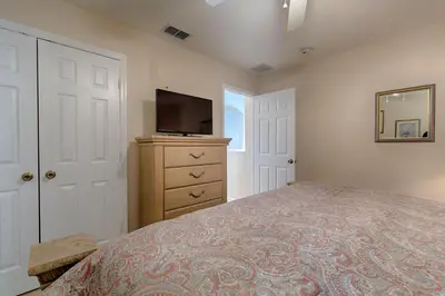 a bedroom with a bed and a tv on a dresser at Resort 5 Bed Private Pool & Spa, Game Room Home in Kissimmee