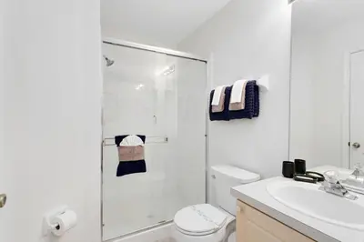 a bathroom with a shower and a toilet and a sink at Four Bedroom/3 Bath South Facing Pool/Spa Villa in Kissimmee