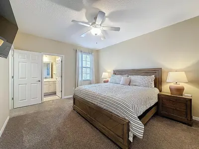 a bedroom with a bed and a ceiling fan at Veranda Home, 8br, 6 en-suites, Lake View,POOL/SPA in Kissimmee