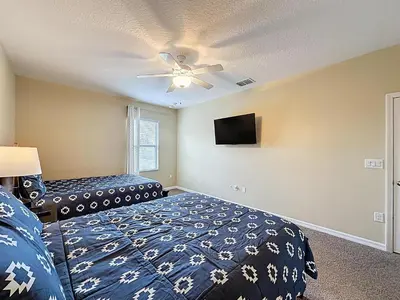 a bedroom with a bed and a ceiling fan at Veranda Home, 8br, 6 en-suites, Lake View,POOL/SPA in Kissimmee