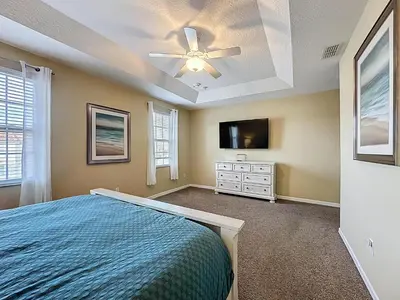 a bedroom with a bed and a ceiling fan at Veranda Home, 8br, 6 en-suites, Lake View,POOL/SPA in Kissimmee
