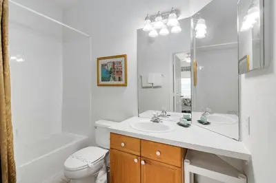 a white bathroom with a sink and a toilet at Amazing Resort 2 bed condo close to Disney in Kissimmee