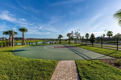 a tennis court in a park with palm trees at Five bedroom home is ideal for an elegant vacation in Kissimmee