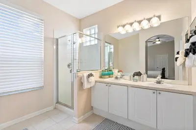 a bathroom with a shower and a sink and a mirror at South Facing Pool 4 Bedroom 3 Bath Villa in Kissimmee