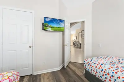a bedroom with a bed and a door leading to a dining room at South Facing Pool 4 Bedroom 3 Bath Villa in Kissimmee