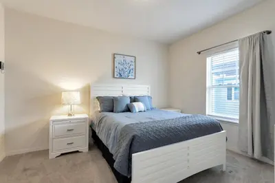 a white bedroom with a bed and a window at Lucaya Village Resort - 4 Bed 3 Bath Townhouse in Kissimmee