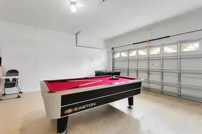 a pool table in a room with a garage at Amazing Disney Dream Getaway in Windsor Palms! in Kissimmee