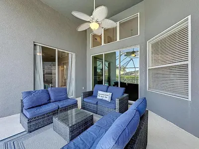 a living room with blue couches and a ceiling fan at Amazing 6 Bed Disney Dream Getaway in Windsor Palm in Kissimmee
