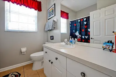 a white bathroom with a toilet and a sink at Making Memories Resort Windsor Palms Condo in Kissimmee