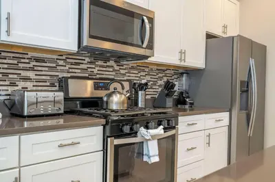 a kitchen with a stove and a microwave at 5 Min to Disney Dream 5 Suites Villa in Orlando