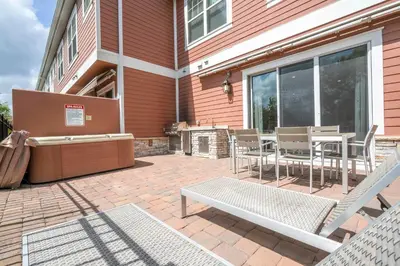 a patio with a grill and a table and chairs at 5 Min to Disney Dream 5 Suites Villa in Orlando