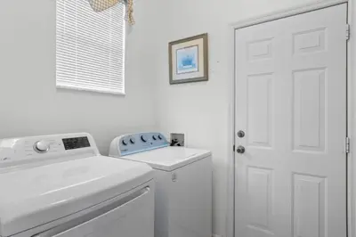 a white laundry room with a washer and dryer at 3Br 2Ba Private Pool Villa just steps away from villa in Kissimmee