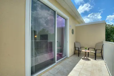 a balcony with sliding glass doors and a table and chairs at Priceless Peace At Serenity By Shine Villas 081 in Orlando
