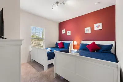 a bedroom with two beds with blue and red walls at Lucky Find Lucaya Resort By Shine Villas 713 in Kissimmee