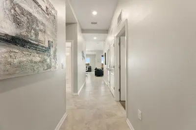 a hallway with white walls and a painting on the wall at Fireworks Night -Storey Lake By Shine Villas #709 in Kissimmee