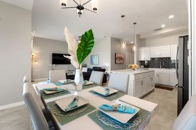 a kitchen and dining room with a table and chairs at Fireworks Night -Storey Lake By Shine Villas #709 in Kissimmee