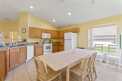 a kitchen with a table and chairs in it at Gilded Parasol By Shine Villas Remington Golf 420 in Kissimmee