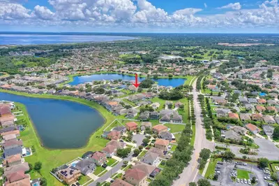 an aerial view of a suburb with houses and water at Gilded Parasol By Shine Villas Remington Golf 420 in Kissimmee
