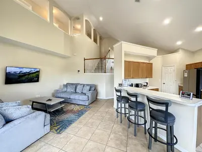 a kitchen and living room with a couch and a table at Luxury 6BD 3.5BA Pool Home in Windsor Palms Resort in Kissimmee