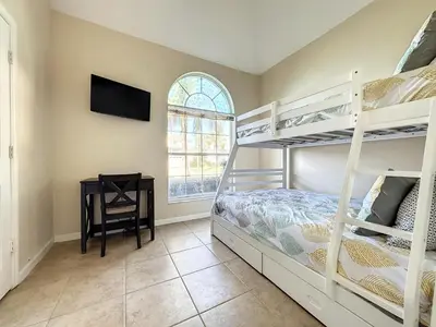 a bedroom with two bunk beds and a table at Luxury 6BD 3.5BA Pool Home in Windsor Palms Resort in Kissimmee