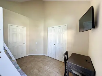 a room with a desk and a tv on a wall at Luxury 6BD 3.5BA Pool Home in Windsor Palms Resort in Kissimmee