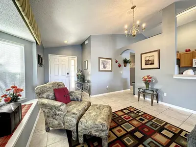 a living room with a couch and a chair at Emerald Island 4 bed mins to Disney in Kissimmee