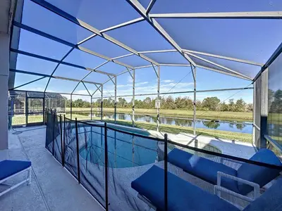 a glass house with a swimming pool on a patio at Emerald Island 4 bed mins to Disney in Kissimmee
