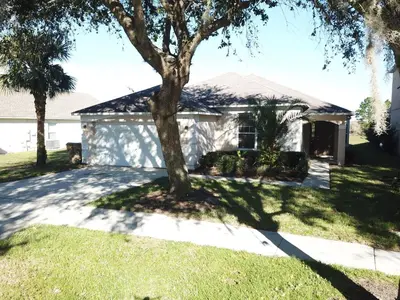 a house with a tree in front of it at Emerald Island 4 bed mins to Disney in Kissimmee