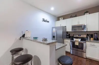 a kitchen with white cabinets and stainless steel appliances at Enjoy a Cozy 3 BR/Clubhouse/Near Disney and more in Kissimmee