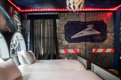 two beds in a room with a wall with a star system at Luxury 9BR Gem- Heated Pool, Theater & Theme Rooms in Kissimmee