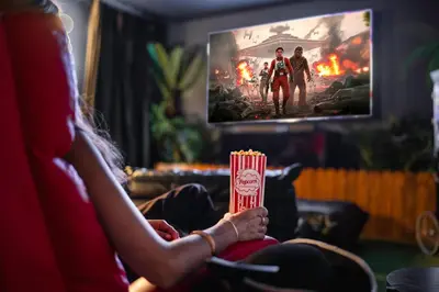 a woman sitting on a couch holding a box of popcorn at Luxury 9BR Gem- Heated Pool, Theater & Theme Rooms in Kissimmee