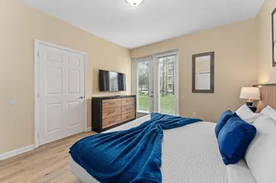 a bedroom with a large bed and a television at Luxury 3-Suite Townhome Resort Near Universal in Orlando