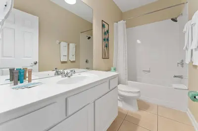 a white bathroom with a sink and a toilet at Luxury 3-Suite Townhome Resort Near Universal in Orlando